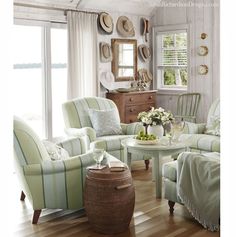 a living room filled with lots of furniture next to a wooden floor covered in white walls