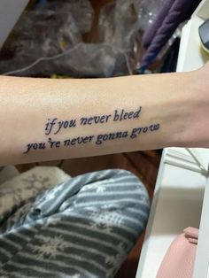 a person with a tattoo saying if you never bleed, you're never gone