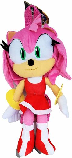 a stuffed animal doll with pink hair and green eyes wearing a red dress, holding a yellow object in her hand