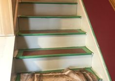 a set of stairs painted green and white with wood treads on the bottom step