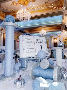 the table is set up with blue and silver decorations, such as balls of yarn