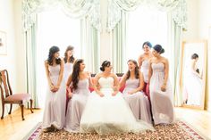 a bride and her bridesmaids pose for a photo in front of the mirror