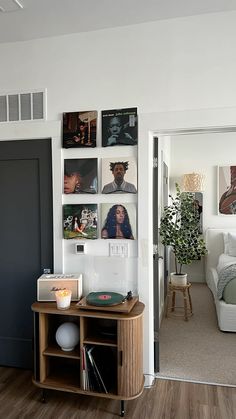 a living room filled with furniture and pictures on the wall