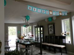 a room filled with lots of furniture and balloons hanging from the ceiling next to windows