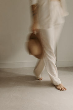 a blurry photo of a person in white pants and shirt with their foot on the ground