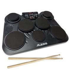 an electronic drum pad with four drumsticks in front of it and two sticks on the side