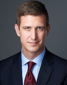 a man in a suit and red tie