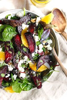 a salad with beets, oranges and feta cheese in a white bowl