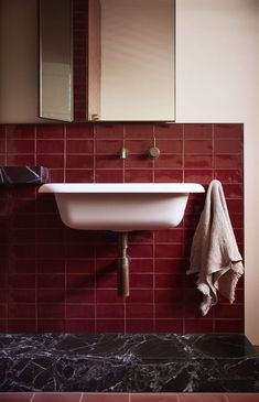 a white sink sitting under a bathroom mirror next to a wall mounted faucet