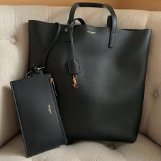 Authentic Black Leather Saint Laurent Purse. New-Never Used. Open At Top With Gold Tone Button Closure. Gold Tone Ysl Detail On Hanging Tassel. Attached Wallet/ Pouch Inside. Perfect Luxury Minimalist Bag. Smoke Free Home. Approximate Measurements: 15 In Across 14 In Tall, 10 Inch Hang On Handle. Plenty Of Room Inside. Easily Opens 14 In Across. Purchased From Saks-Faint Line Across Inside Tag. Saint Laurent Purse, Ysl Bags, Minimalist Bag, Wallet Pouch, Saint Laurent Bag, Leather Purse, Ysl Bag, 10 Inch, Leather Purses