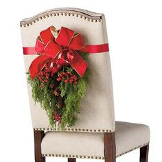 a chair with a christmas wreath on it and a red bow hanging from the back