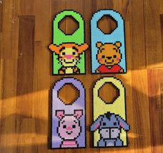 four door hangers made out of perler beads on a wooden floor with the same pattern