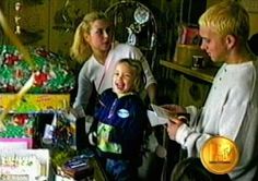 a young boy is laughing while surrounded by other people