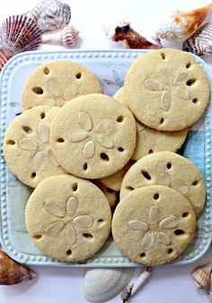 some cookies that are on a plate with the words almond sand dollar cookies in front of them