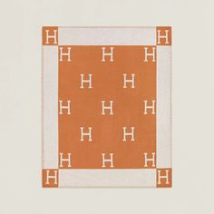 an orange and white area rug with the letter h on it's center square