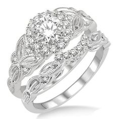 a white gold engagement ring set with an intricate design on the band and center stone