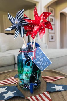 a patriotic centerpiece in a mason jar with red, white and blue pinwheels