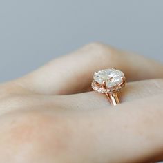 a woman's hand holding a diamond ring