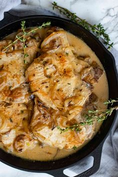 chicken and mushroom stew in a cast iron skillet with fresh thyling sprigs