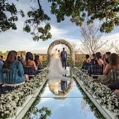 a bride and groom standing at the end of their wedding ceremony in front of an audience