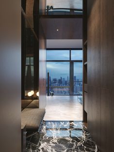 a hallway leading to a living room with large windows