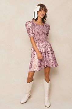 The Michelle Dress is the perfect mix of playful and chic. Made with a stunning purple floral knit fabric, this knee-length women's dress features a unique square neckline and 1/2 length fitted sleeves with a subtle puff at the cap. The asymmetrical tiered skirt adds a fun twist, while the hidden back zipper and smocked bodice provide a flattering fit. Maternity friendly too! Purple Fitted Tiered Dress, Fitted Mini Dress With Square Neck In Purple, Purple Fitted Mini Dress With Puff Sleeves, Feminine Fitted Mini Dress With Tiered Skirt, Fitted Feminine Mini Dress With Tiered Skirt, Purple Fitted Square Neck Dress, Purple Fitted Dress With Square Neck, Fitted Ruched Mini Dress With Tiered Skirt, Fitted Purple Dress With Square Neck