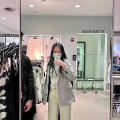 a woman standing in front of a mirror taking a selfie