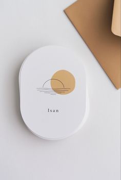 a white coaster sitting on top of a table next to a brown envelope and pen