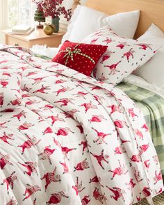 the comforter is red and white with deers on it, along with pillows