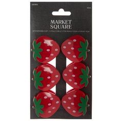 four red strawberries with green leaves on them in a package for the market square