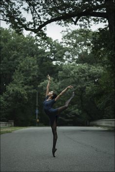 a young woman is dancing in the middle of the street with her legs spread out