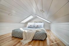 a bed sitting inside of a bedroom on top of a wooden floor