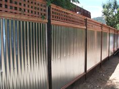 a long metal fence next to a tree