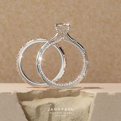 two wedding rings sitting on top of each other