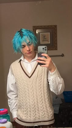 a man with blue hair taking a selfie in front of a mirror wearing a sweater and vest