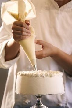 a person is cutting into a cake with a large pastry cone on top of it