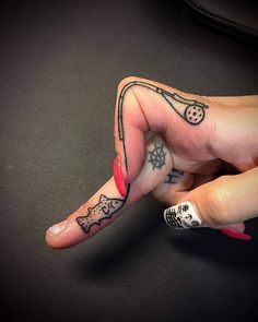 a woman's hand with tattoos on her fingers pointing to the left and right