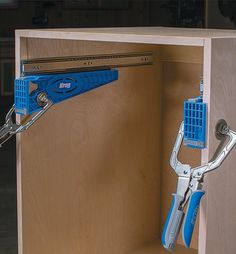 a pair of pliers are being used to open a cabinet door with tools attached