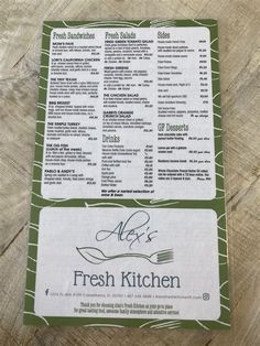 a menu for fresh kitchen on a wooden table