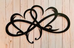 a metal wall hanging on the side of a wooden wall with two hearts in it