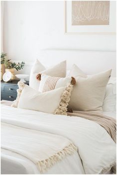 a white bed topped with lots of pillows