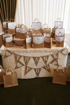 a table topped with brown paper bags filled with thank you