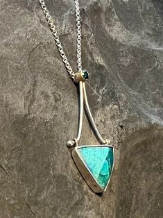 Beautiful Shattuckite bezel set in Sterling silver dramatically dangling from a London Blue Topaz bezel set in 14K yellow gold on a movable Sterling silver hinge Pendant total length is 1 1/2" by 5/8" at the widest point Solid Sterling silver cable chain is adjustable 16 -18" with lobster claw clasp