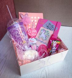 a box filled with candy, candies and lollipops on top of a table