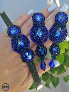 a woman's hand holding three blue bracelets