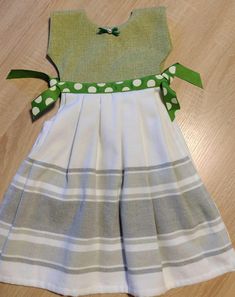 a dress made out of fabric with green and white polka dots on the collarline