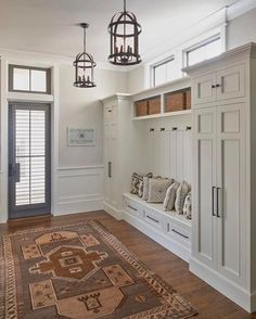 an image of a room with some white cabinets and drawers on the wall next to a large rug