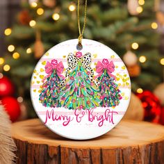 a christmas ornament hanging from a tree on top of a wooden table next to a christmas tree