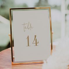 a table number is displayed on a gold frame