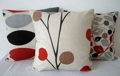 three decorative pillows sitting on top of a bed